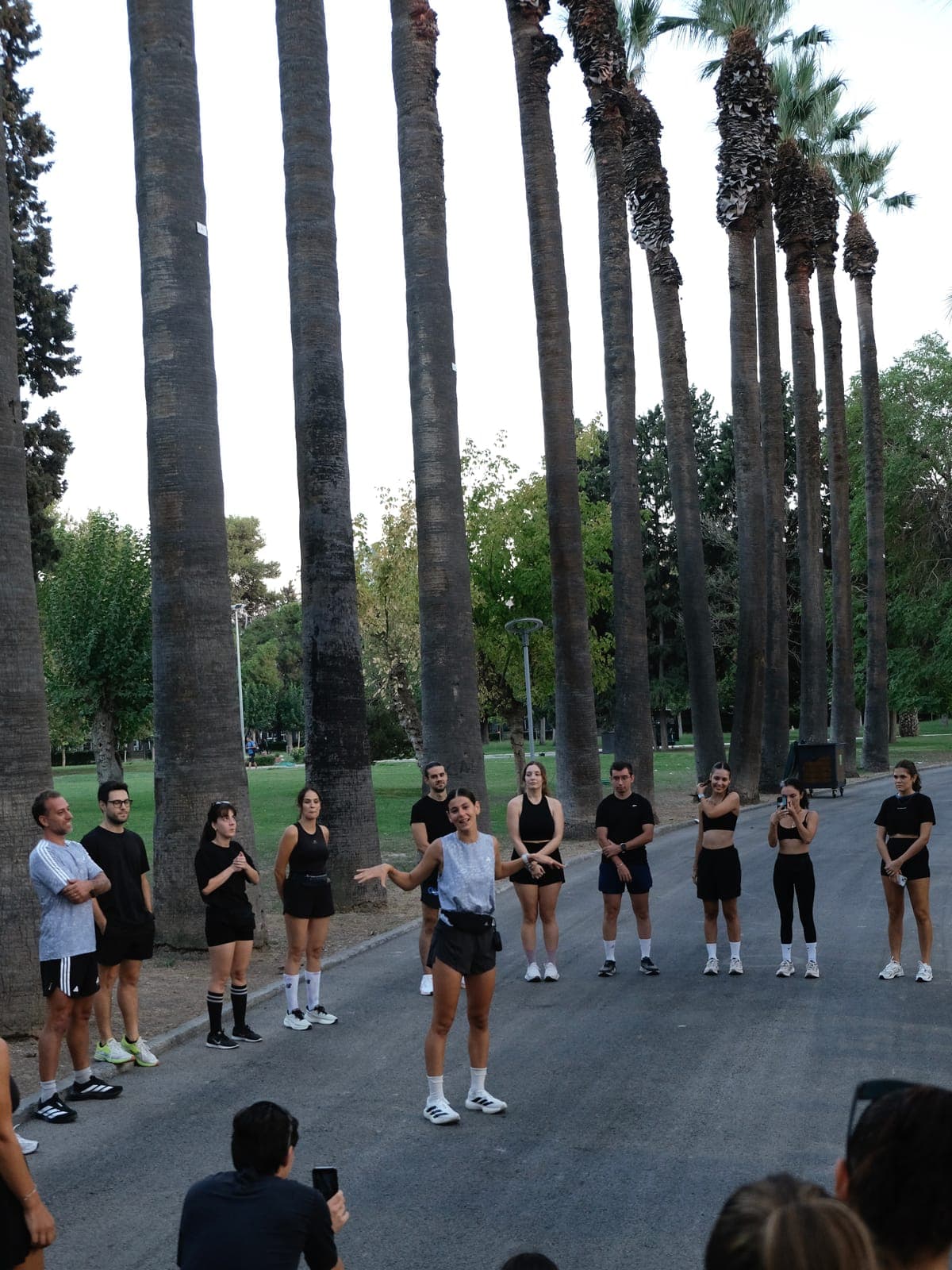 Naz Karagözoğlu palmiyeli bir parkta Alsancak Runners grubuna hitap ederken